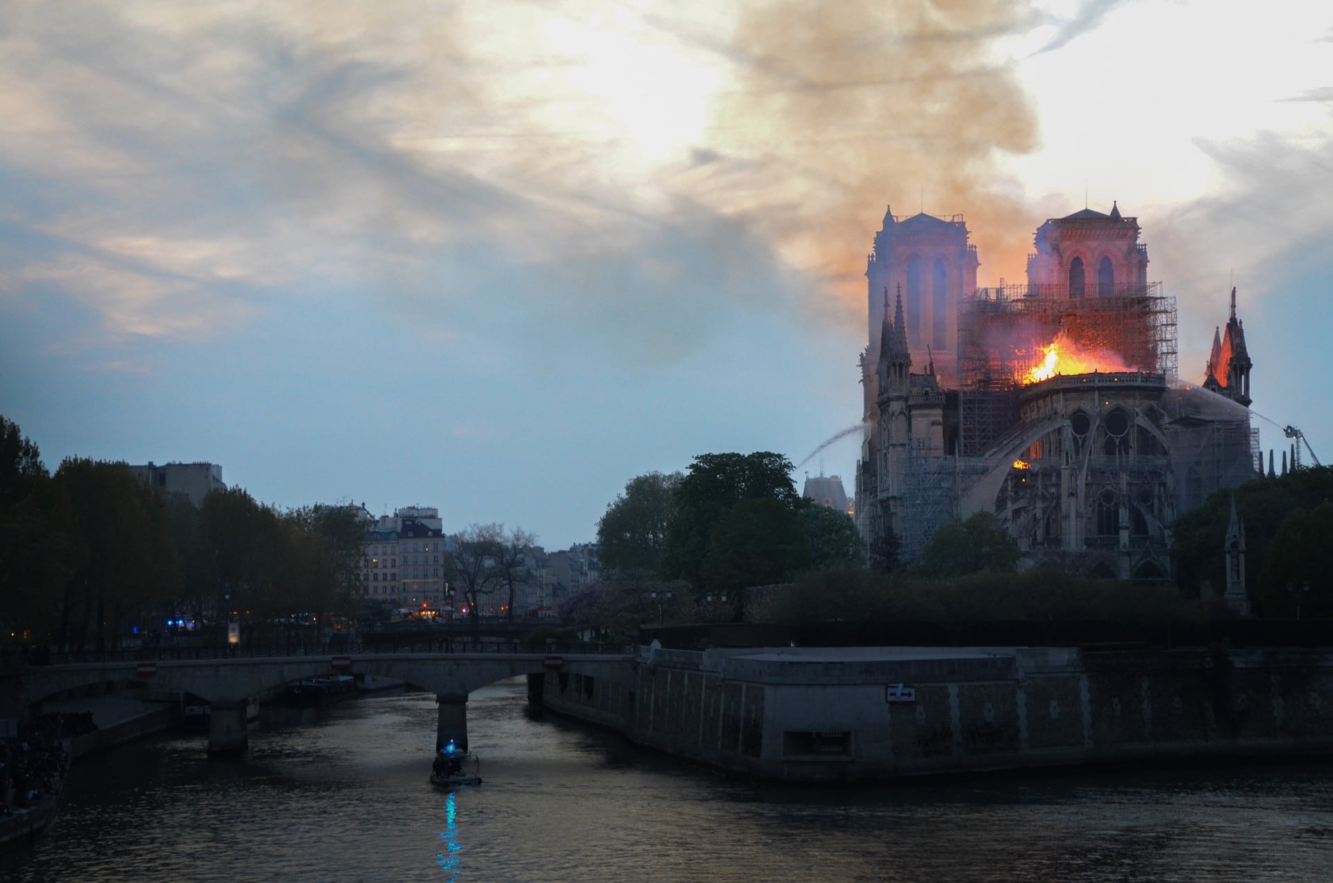 Notre-Dame Cathedral background image on Friends of Notre-Dame de Paris' official fundraising website. This picture was taken during the fire. You can see the fire fighters trying to contain and kill the fire that started in the roof of Notre-Dame Cathedral.
